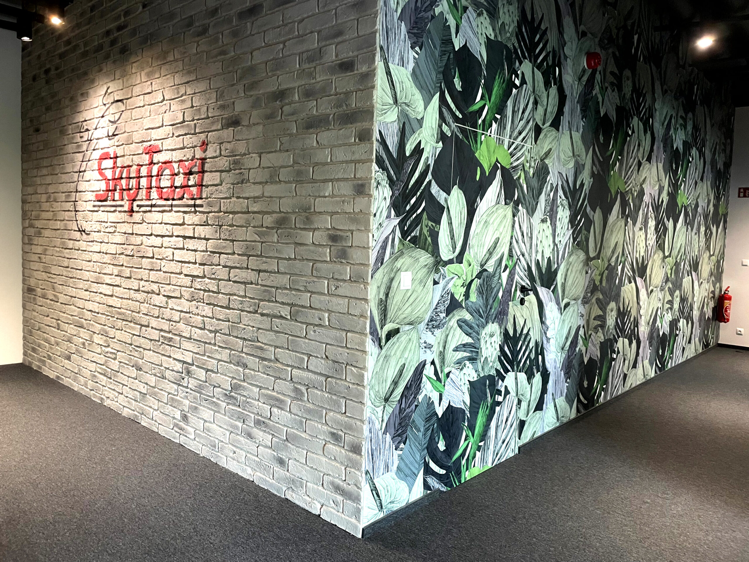 Logo SkyTaxi na ceglanej ścianie w strefie wejściowej biura – Wrocław