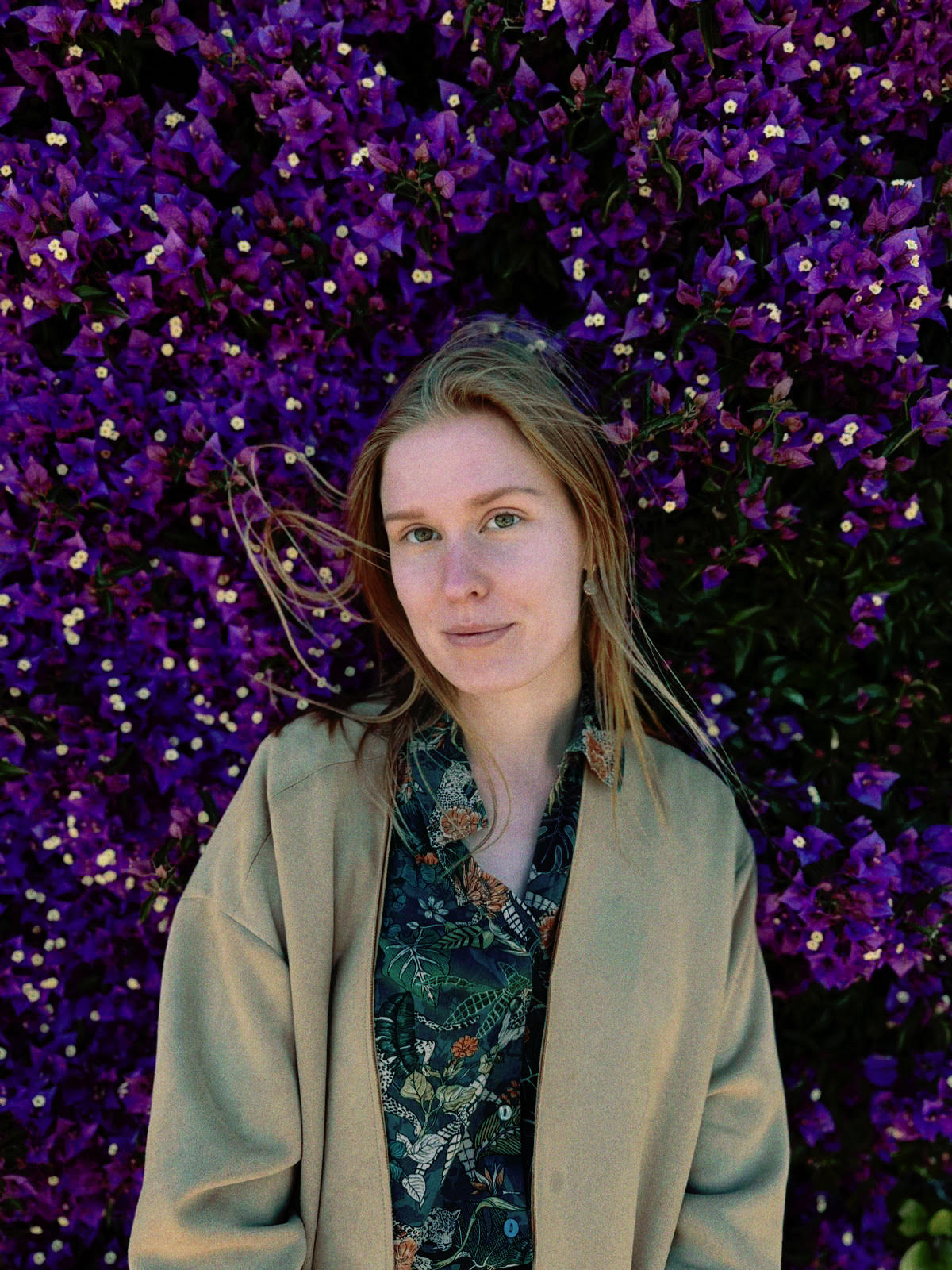 Projektantka wnętrz Babahaus na tle kwitnącej purpurowej ściany z bougainvilleą – portret w stylu naturalnym